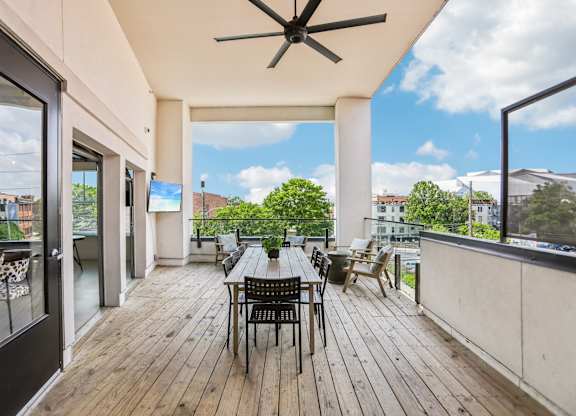 A patio with a table and chairs overlooking a cityscape.