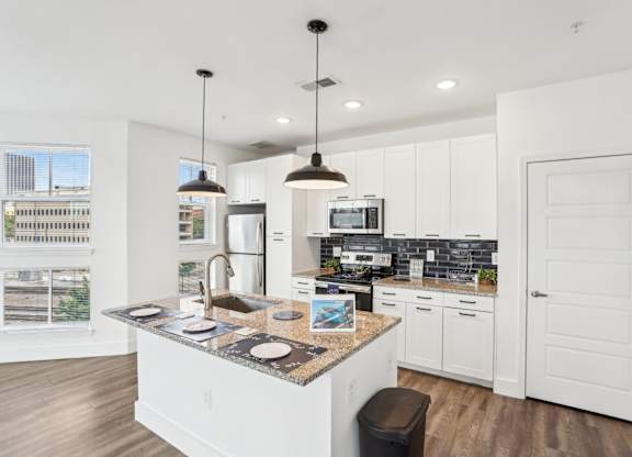A kitchen with white cabinets and a granite countertop.