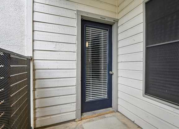 A white house with a dark blue door and window.