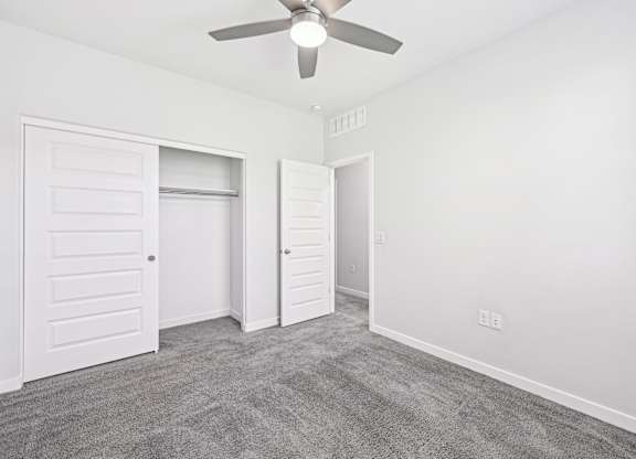 Baseline on 16th townhome bedroom with a ceiling fan and two doors.
