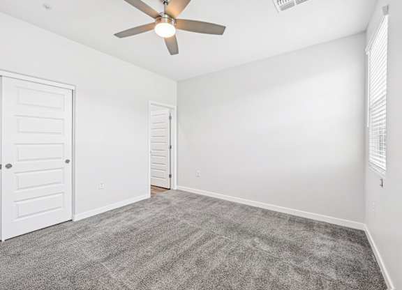 Baseline on 16th townhome room with a ceiling fan and carpeted floor.