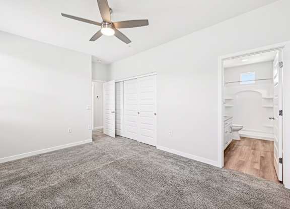 Baseline on 16th townhome room with a ceiling fan and carpeted floor.
