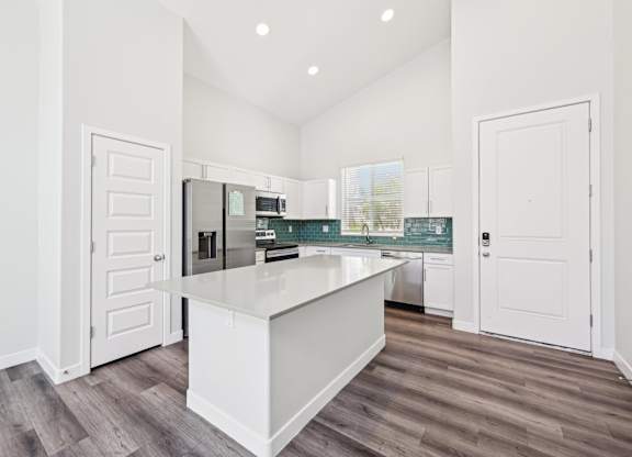 Baseline on 16th townhome kitchen with white cabinets and a white island.