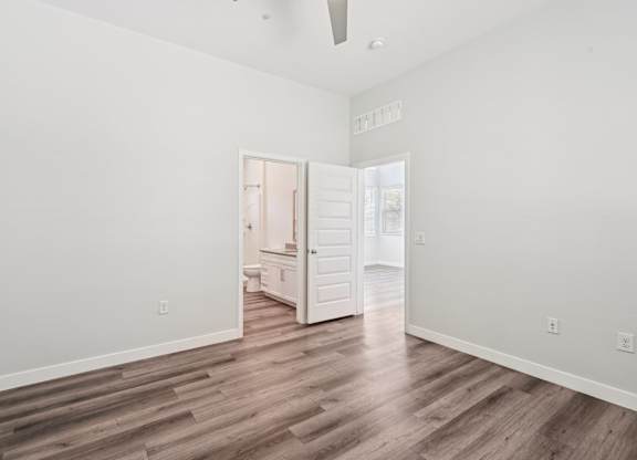 Baseline on 16th townhome bedroom with a wooden floor and a white ceiling with a fan.