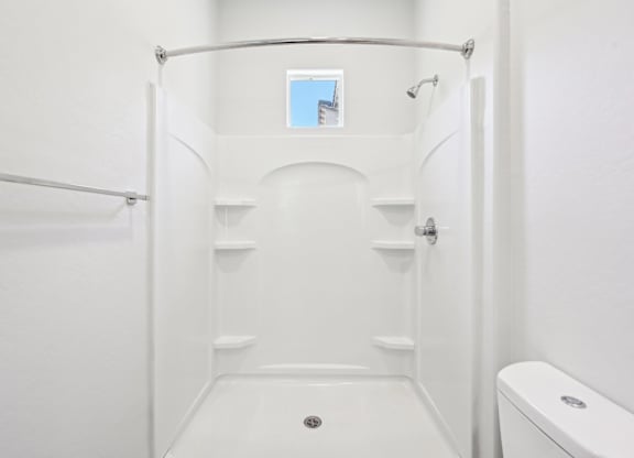 Baseline on 16th townhome white bathroom with a toilet and a walk in shower.