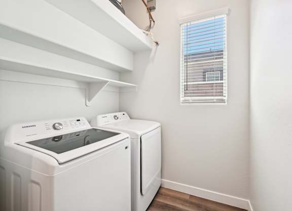 Baseline on 16th townhome white washing machine and dryer in a small laundry room.