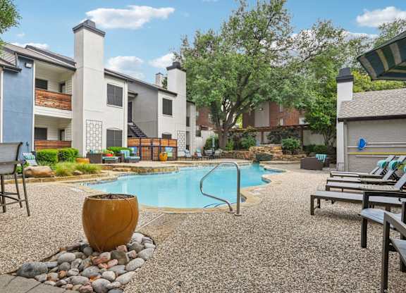 A pool surrounded by chairs and a large vase.