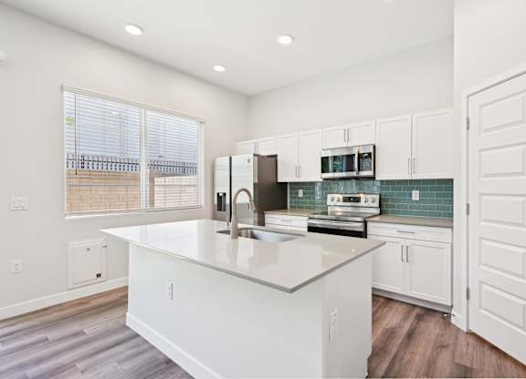 Baseline on 16th townhome kitchen with white cabinets and a large island.