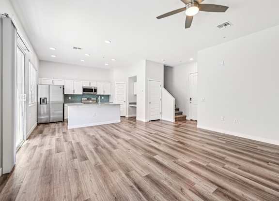 Baseline on 16th townhome spacious kitchen with wooden floors and white walls.