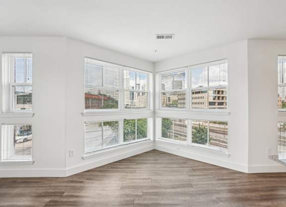 A room with a view of the city through large windows.