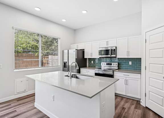 Baseline on 16th townhome kitchen with white cabinets and a large island.