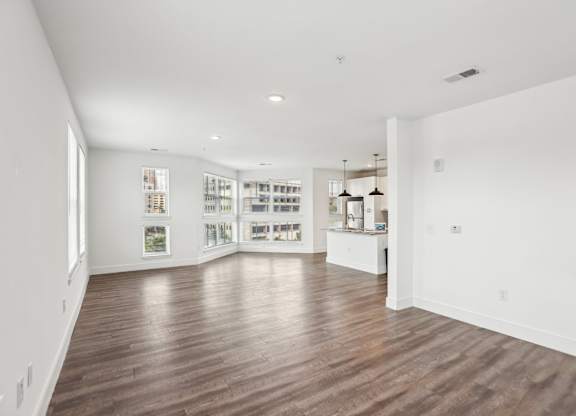 A spacious room with wooden floors and white walls.