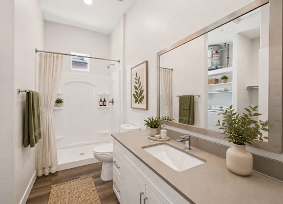 A bathroom with a toilet, sink, and mirror.