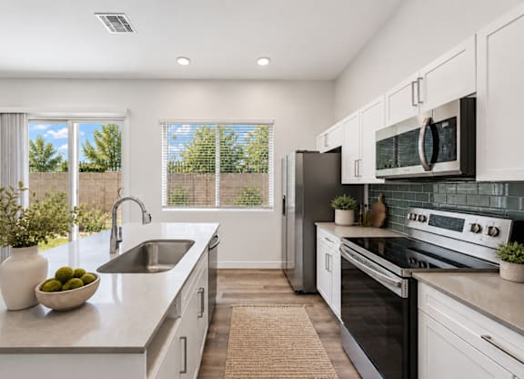 A modern kitchen with a large island and stainless steel appliances.