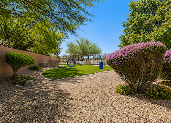 A garden with a gravel path and a blue sign in the middle.