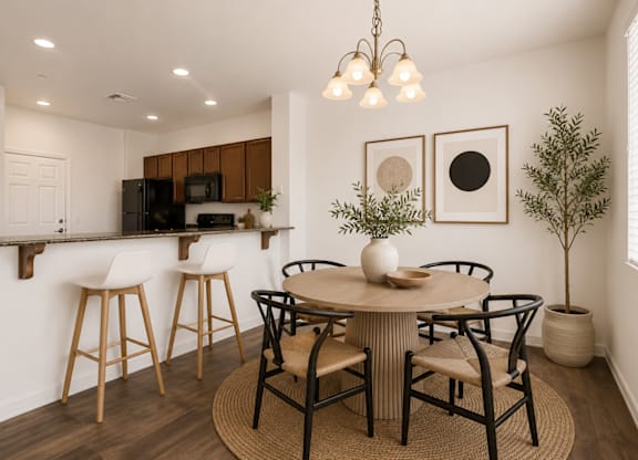A kitchen with a bar area and a dining table set up.