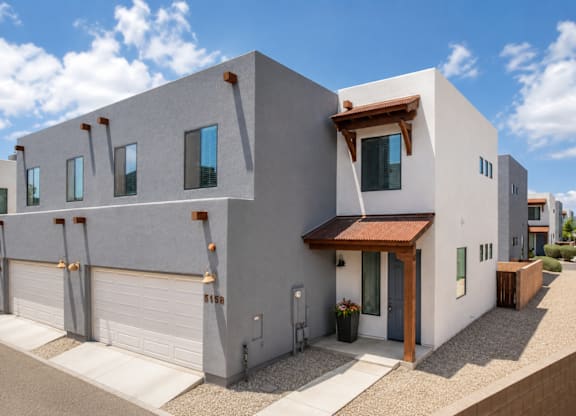A modern house with a grey exterior and a brown roof.