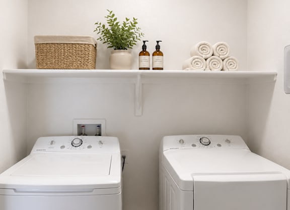 A white bathroom with two sinks and a shelf above them.