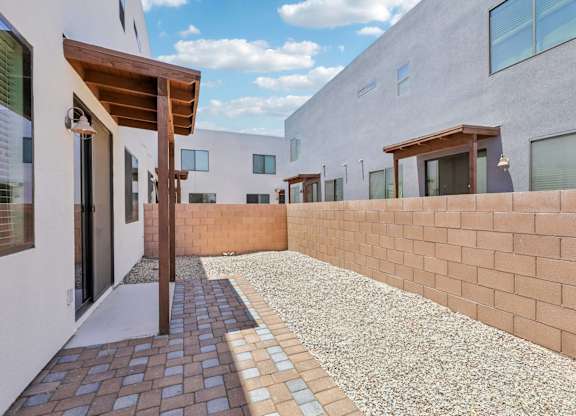 A modern building with a brick wall and a gravel pathway.