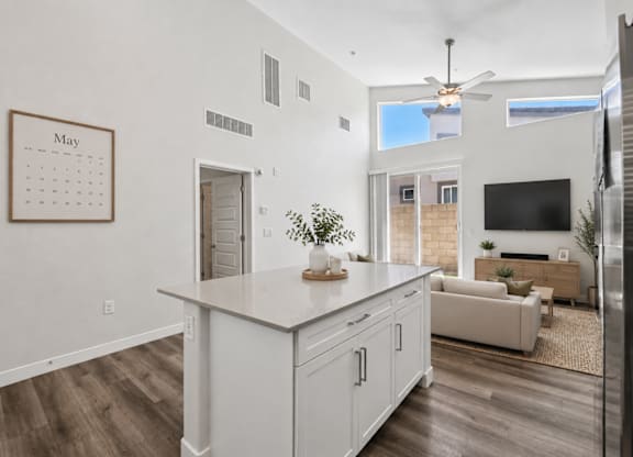 A kitchen with a calendar on the wall and a refrigerator on the right.