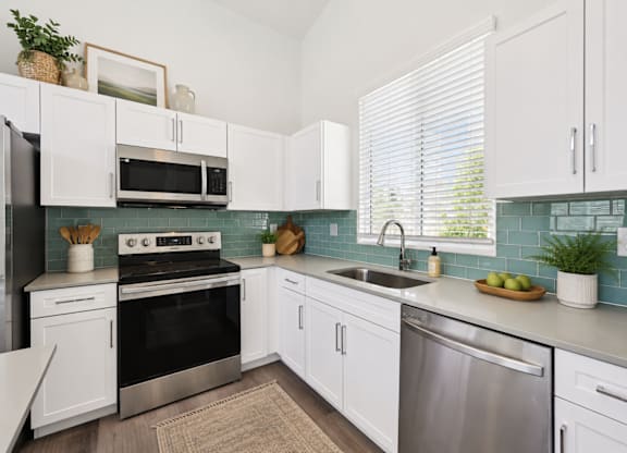 A kitchen with white cabinets and a black stove top oven.