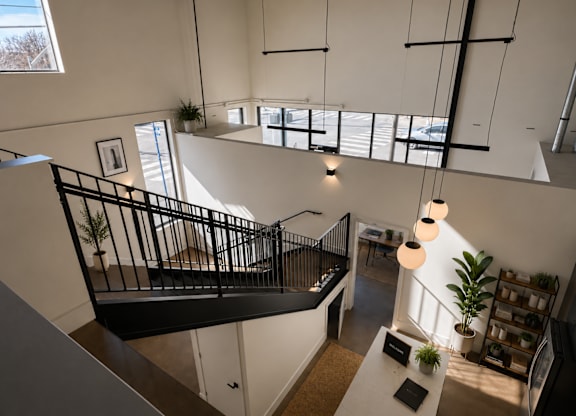 A black metal staircase with a white railing and a white table with a plant on it.
