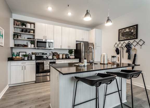 A modern kitchen with a large island and bar stools.