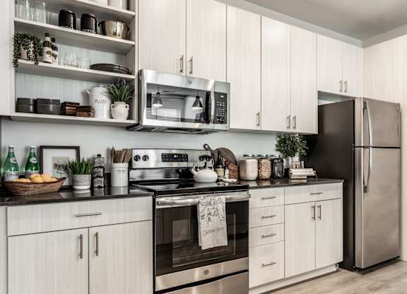 A modern kitchen with white cabinets and stainless steel appliances.