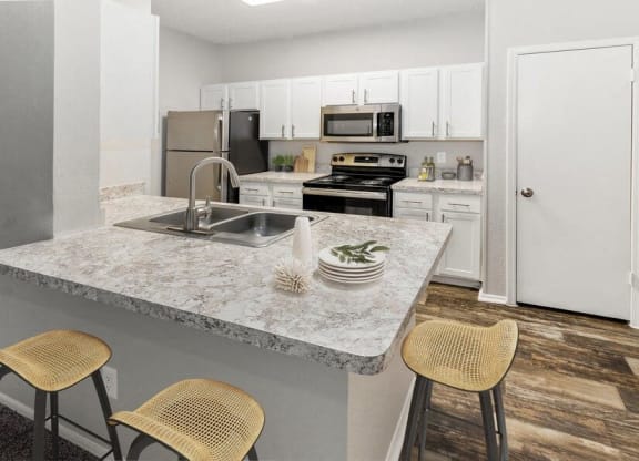 a kitchen with a marble counter top and a sink at Heatherstone, Texas