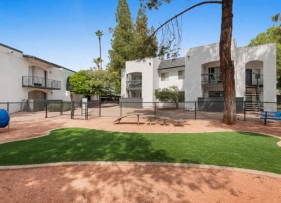 the backyard of an apartment building with a playground and grass at Vertu, Phoenix
