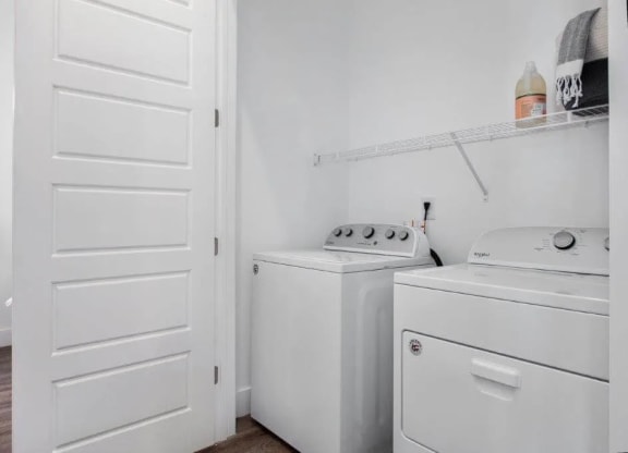a small laundry room with a washer and dryer and a white door at Smith and Porter, Georgia, 30313