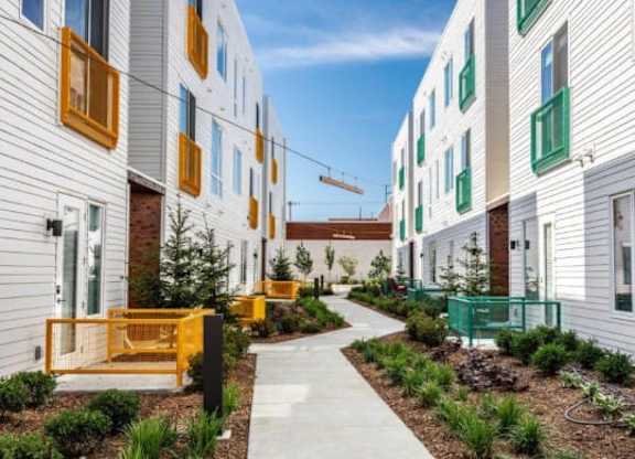 A modern apartment complex with a walkway between the buildings.