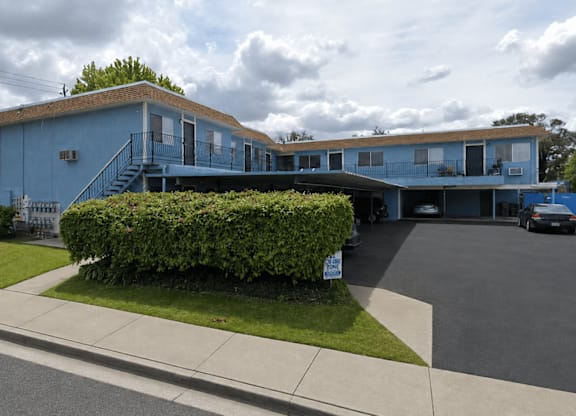 A blue building with a parking lot in front.