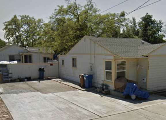 a small white house with a yard in front of it