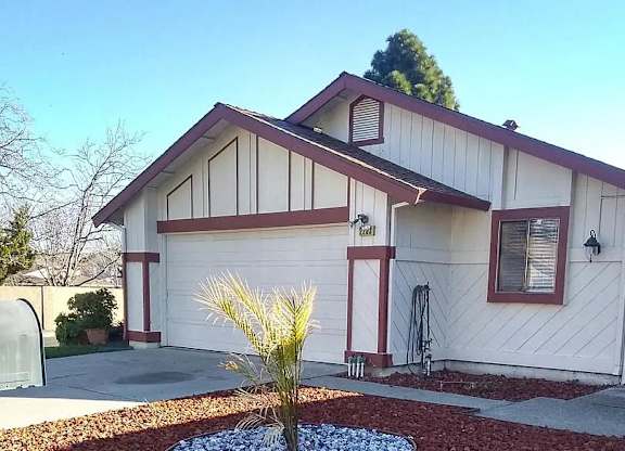 a white house with a garage and a palm tree