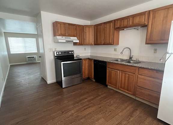 an empty kitchen with wooden floors and wooden cabinets