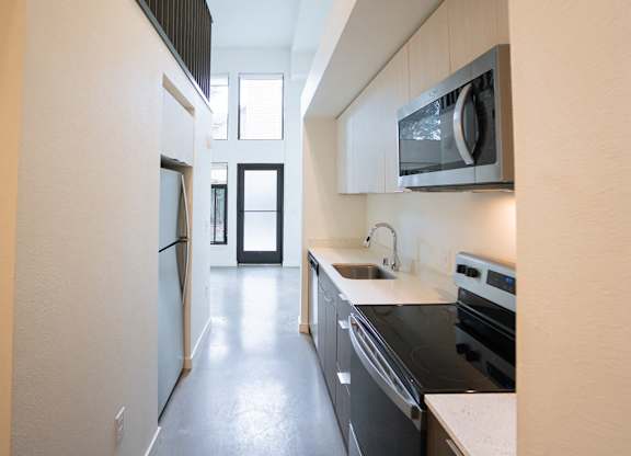 A modern kitchen with black appliances and white countertops.