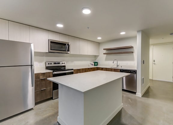 A modern kitchen with a refrigerator, stove, and oven.