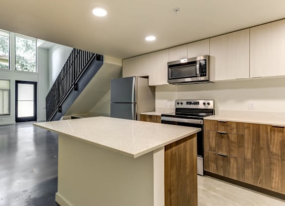 A kitchen with a white counter top and wooden cabinets.