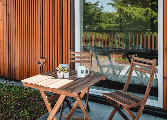 A wooden table with two chairs and a cup on it.