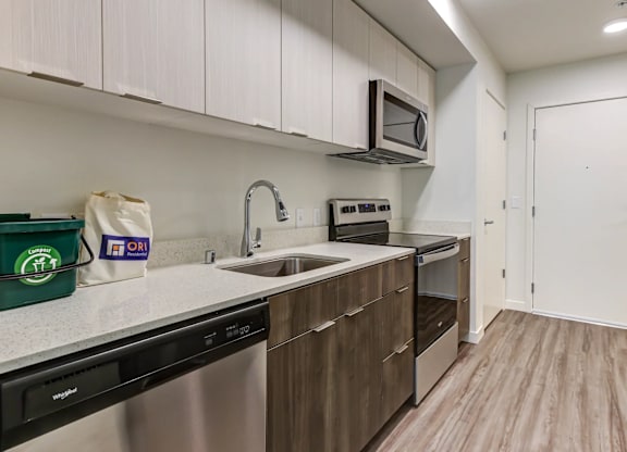 A kitchen with white cabinets and a black dishwasher.