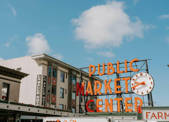 a sign for the public market center with a clock
