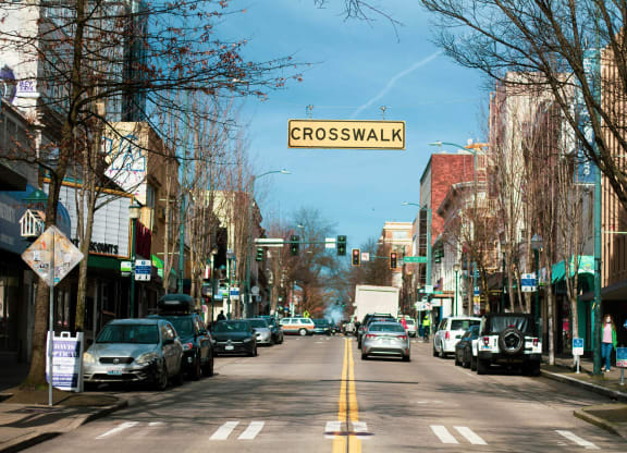 a city street with cars and a crosswalk sign