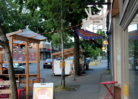 a city street with a cafe and tables on the sidewalk