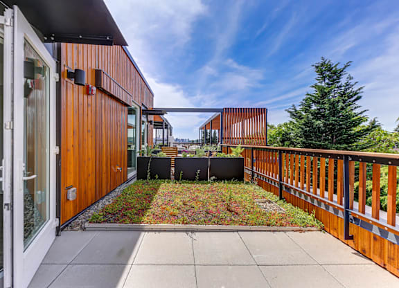 A balcony with a view of the sky and a tree.