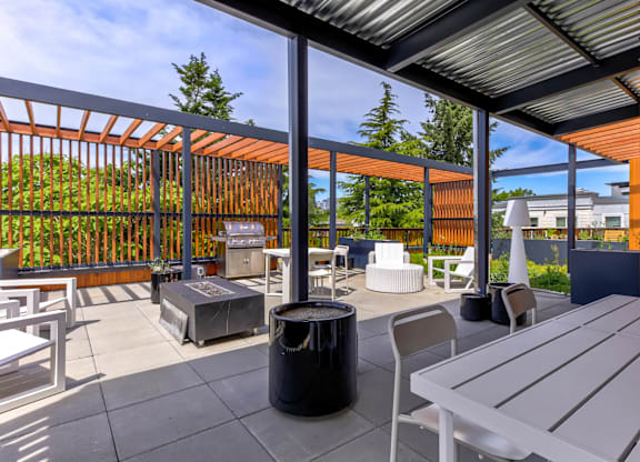 A patio with a table and chairs under a roof.