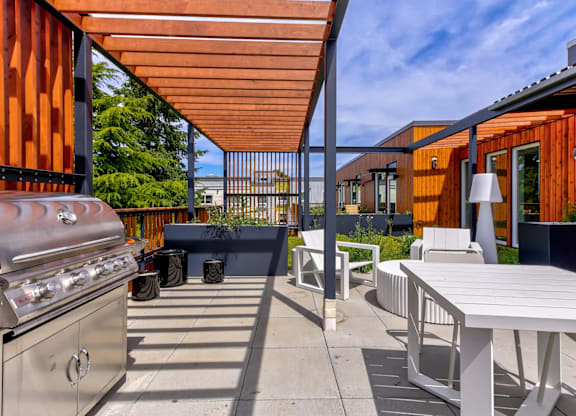 A patio with a grill and a table.