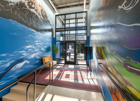 a lobby with a large mural of the ocean and stairs