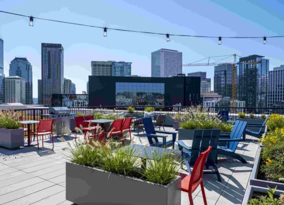 a roof top patio with chairs and tables and a view of the city