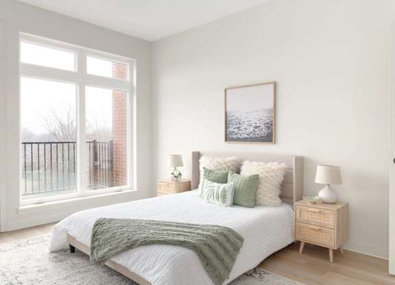 A bedroom with a large bed and a picture on the wall.